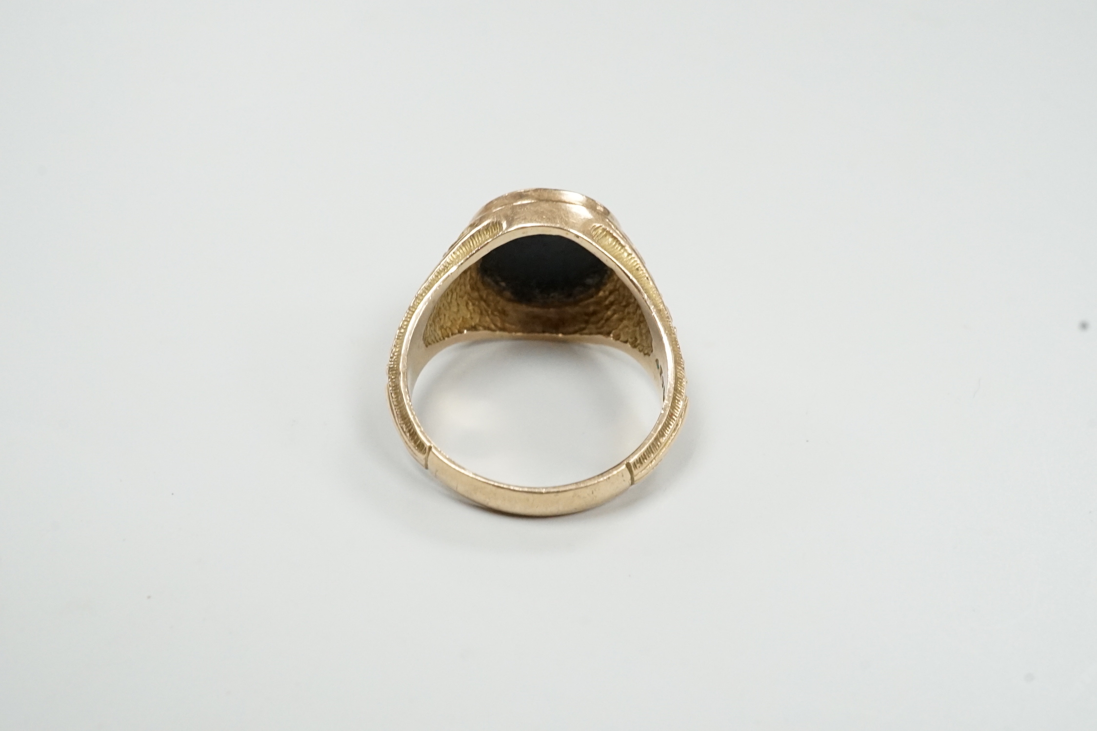A 1970's 9ct gold and black onyx? set signet ring, carved with the bust of a Roman soldier, size T, gross weight 8 grams.